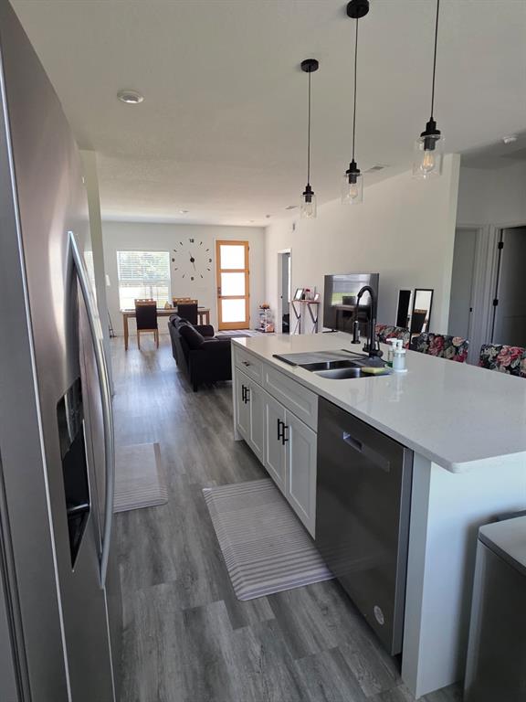 A kitchen island with a stainless steel dishwasher faces a dining area and living room — 14886 SW 43RD COURT, OCALA, FL