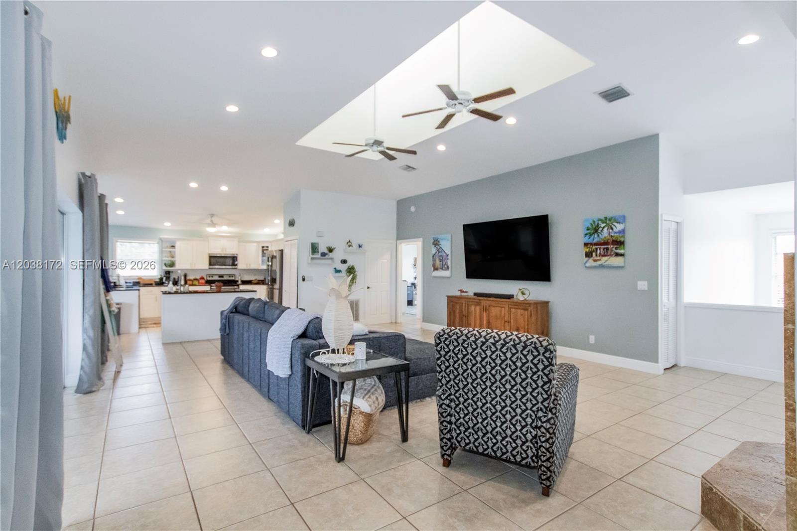 A living room with a blue accent wall, tile flooring, and a recessed ceiling area — 14500 bokeelia rd, Bokeelia FL 33922, BOKEELIA, FL