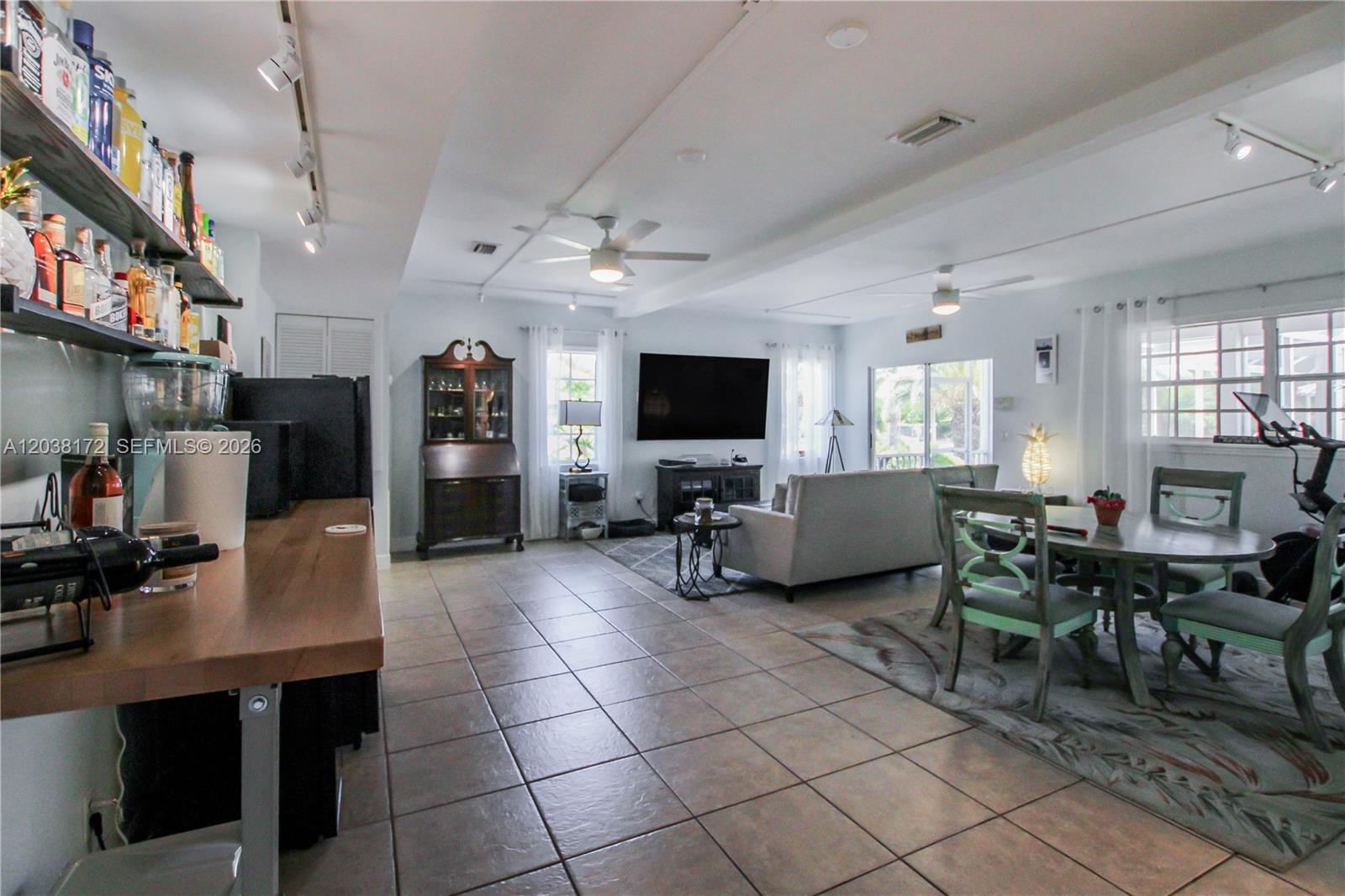 A spacious open-concept living area features a home bar, dining set, and tile flooring — 14500 bokeelia rd, Bokeelia FL 33922, BOKEELIA, FL