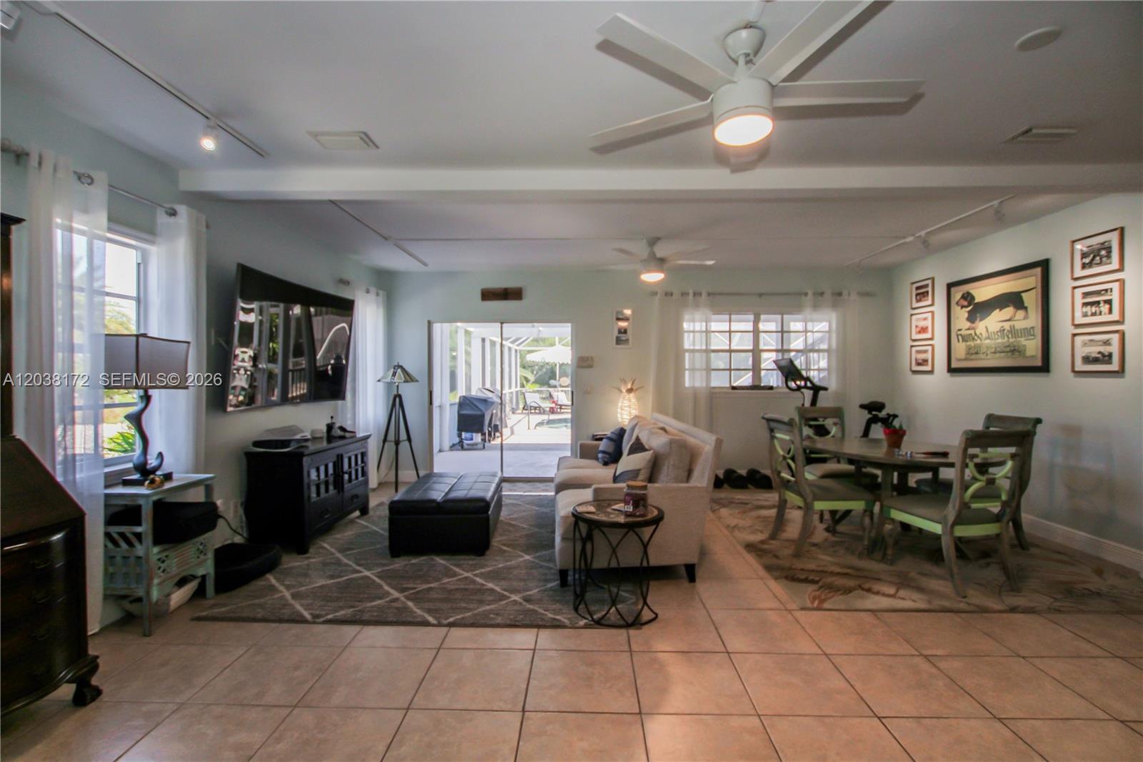 A living and dining room area features tile floors, a ceiling fan, and sliding glass doors — 14500 bokeelia rd, Bokeelia FL 33922, BOKEELIA, FL