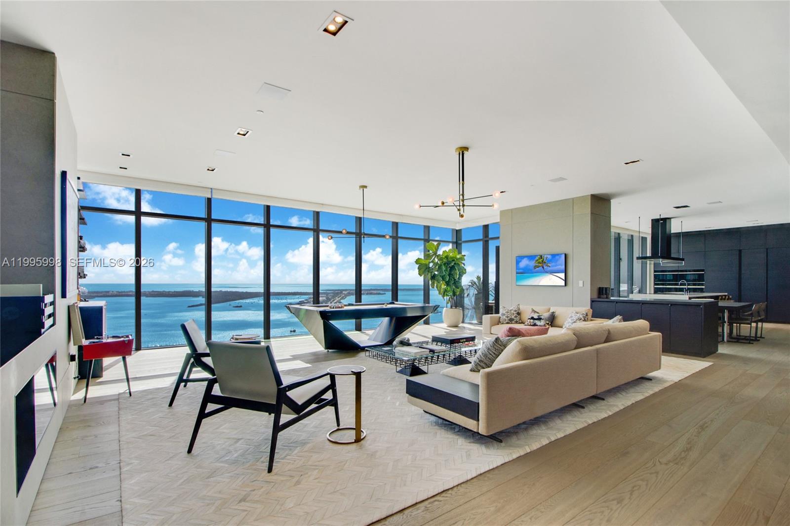 A modern living room features a pool table, floor-to-ceiling windows, and panoramic ocean views — 1451 Brickell Ave # 4301, Miami FL 33131, MIAMI, FL
