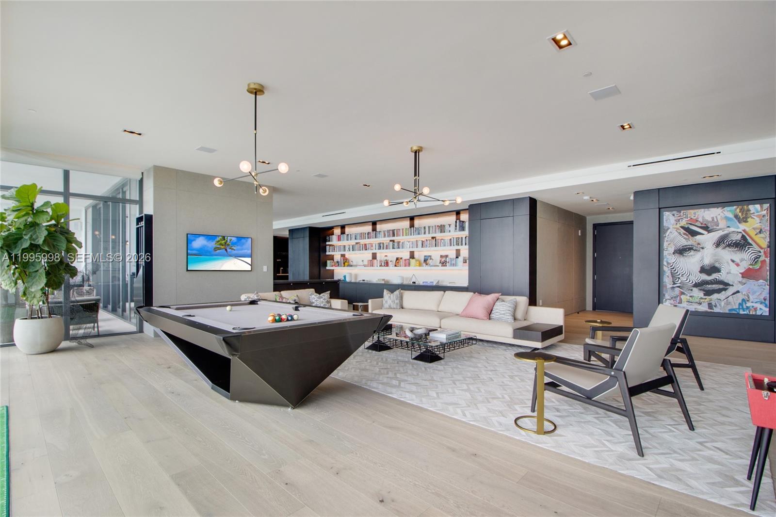 A modern living room features a pool table, a sofa, bookshelves, and contemporary light fixtures — 1451 Brickell Ave # 4301, Miami FL 33131, MIAMI, FL