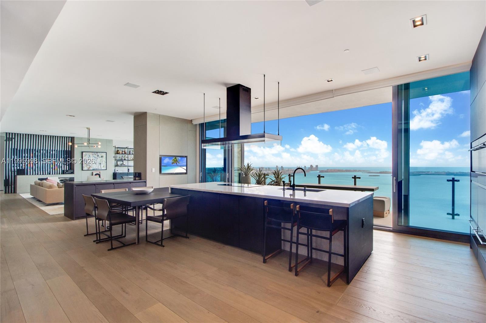 A modern kitchen with a large island and dining area overlooks a panoramic ocean view — 1451 Brickell Ave # 4301, Miami FL 33131, MIAMI, FL