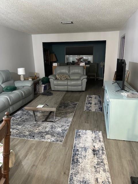 A living room features light gray leather sofas, a wooden coffee table, and area rugs — 4079 LAKE BAYSHORE DRIVE UNIT 308, BRADENTON, FL