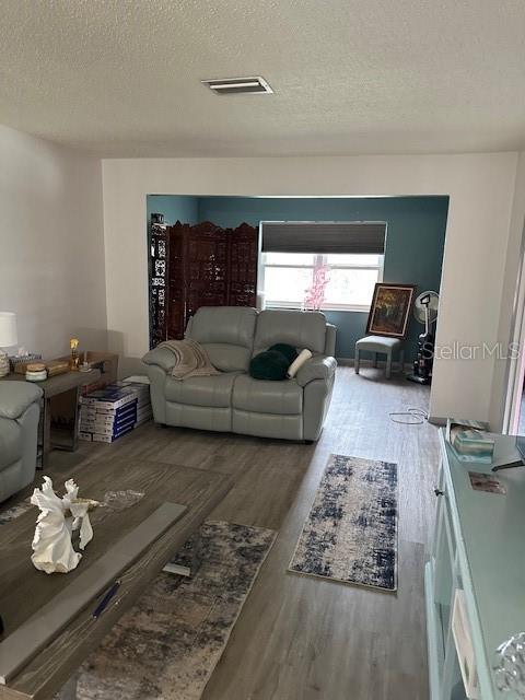 A living room features light gray flooring, a light gray loveseat, and a blue accent wall — 4079 LAKE BAYSHORE DRIVE UNIT 308, BRADENTON, FL