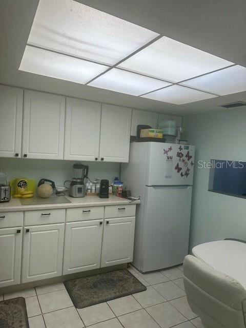 A kitchen features white cabinets, a white refrigerator, and a large recessed ceiling light — 4079 LAKE BAYSHORE DRIVE UNIT 308, BRADENTON, FL