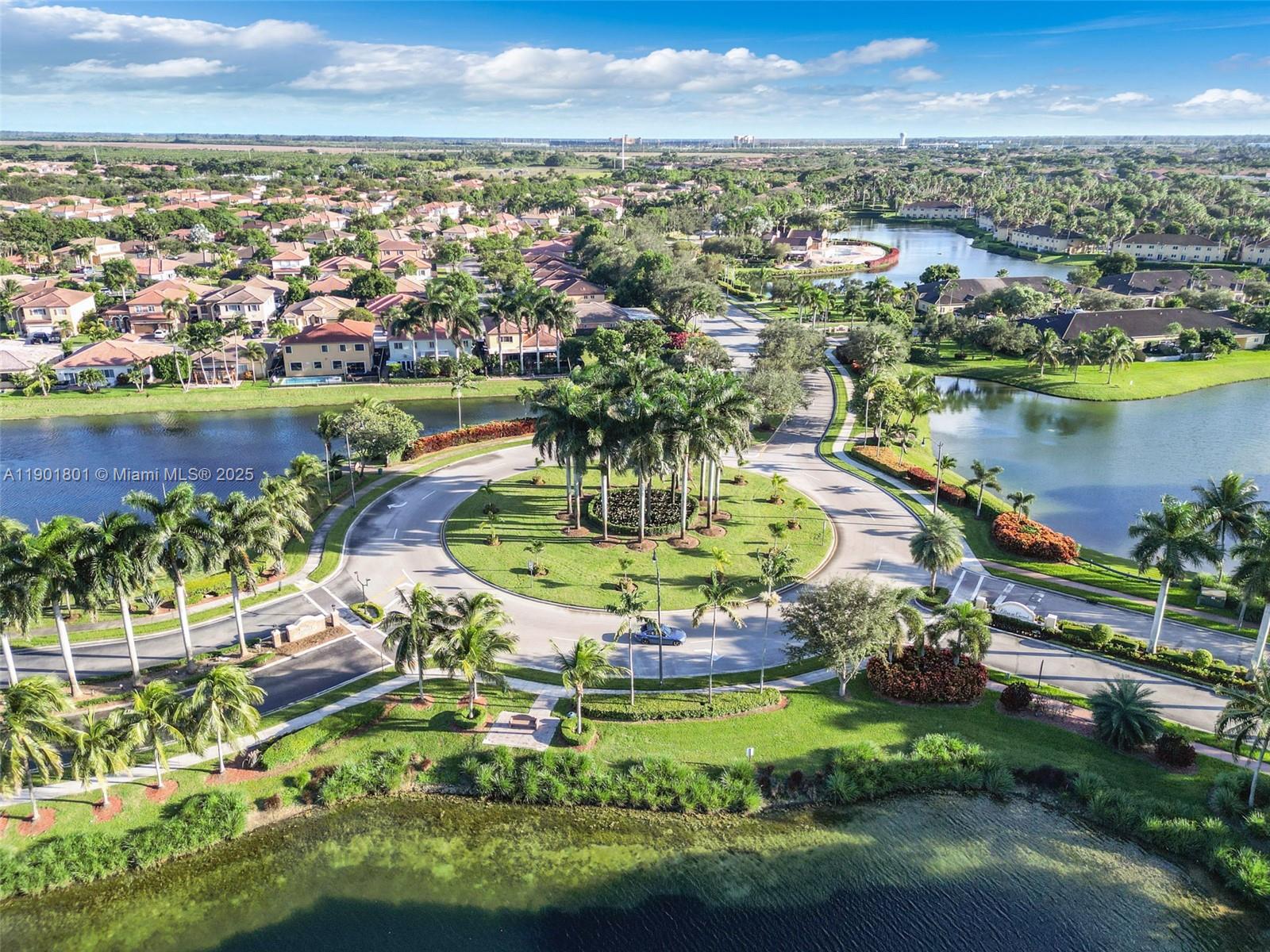 An aerial view shows a residential neighborhood with a central roundabout and surrounding lakes — 1595 NE 33rd Rd # 3, Homestead FL 33033, HOMESTEAD, FL