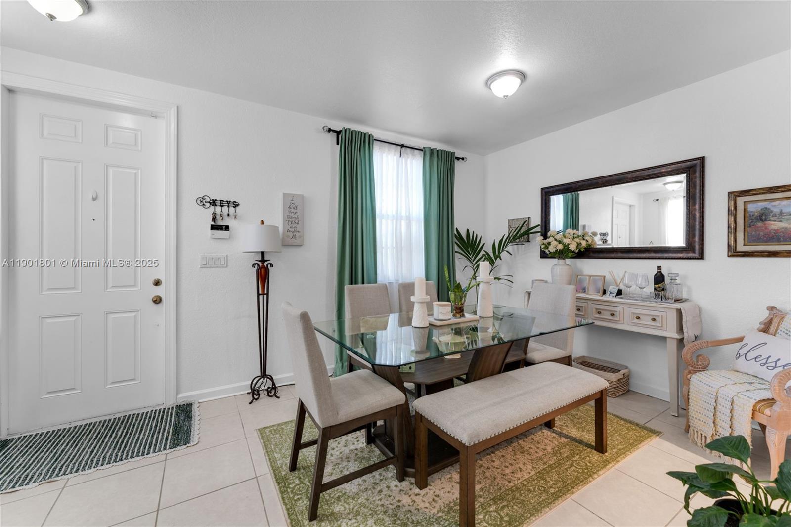 A dining room features a glass-topped table, upholstered chairs, a bench, and a wall mirror — 1595 NE 33rd Rd # 3, Homestead FL 33033, HOMESTEAD, FL
