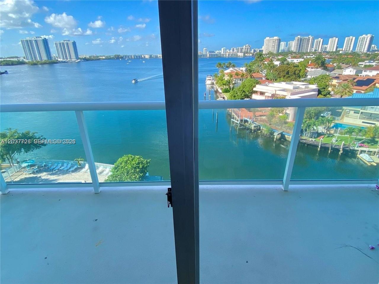A balcony overlooks a bay with high-rise buildings and residential homes in the distance — 2841 NE 163rd St # 803, North Miami Beach FL 33160, NORTH MIAMI BEACH, FL