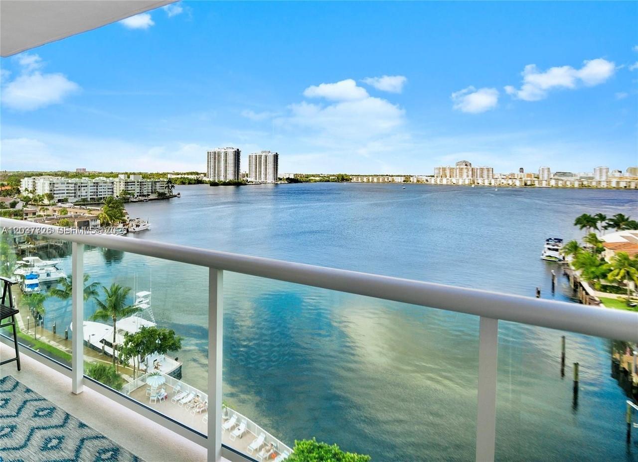 A balcony with a glass railing overlooks a wide bay with boats and distant buildings — 2841 NE 163rd St # 803, North Miami Beach FL 33160, NORTH MIAMI BEACH, FL