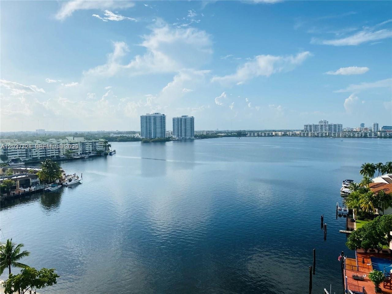 An elevated view of a calm bay surrounded by residential buildings and palm trees — 2841 NE 163rd St # 803, North Miami Beach FL 33160, NORTH MIAMI BEACH, FL