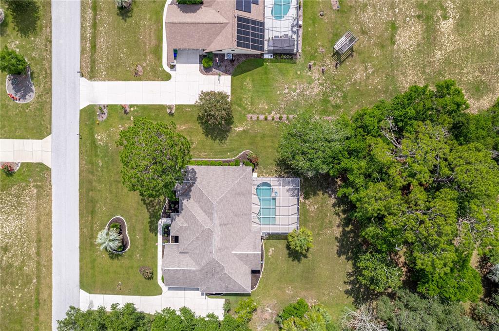 An aerial view shows two houses with swimming pools and large yards in a neighborhood — 1154 E TRIPLE CROWN LOOP, HERNANDO, FL