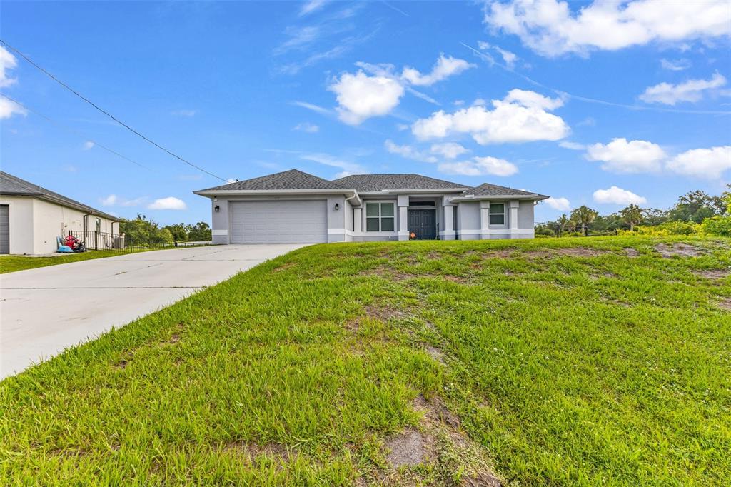 A single-story house with a gray exterior, a two-car garage, and a large front lawn — 4443 CINDERELLA CIRCLE, NORTH PORT, FL