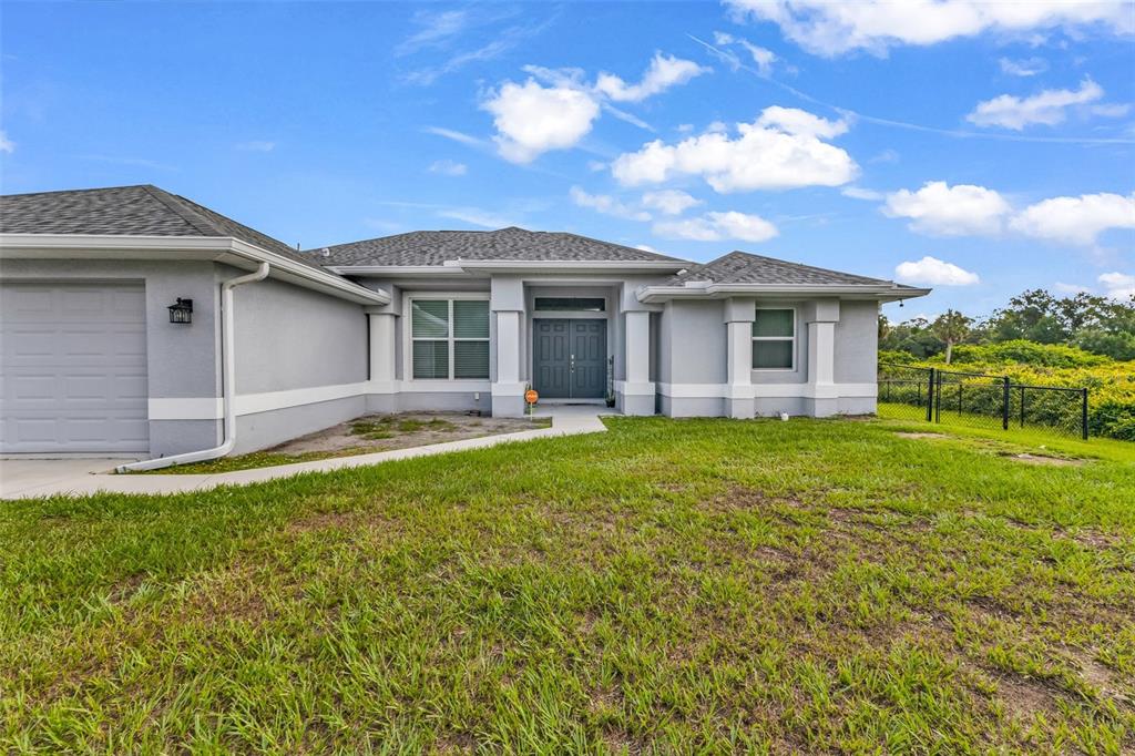 A single-story gray house with a garage, front entrance, and a grassy yard — 4443 CINDERELLA CIRCLE, NORTH PORT, FL