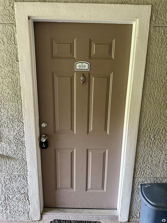 A brown front door with a silver knocker and a lockbox is set in a wall — 3373 S KIRKMAN ROAD UNIT 939, ORLANDO, FL