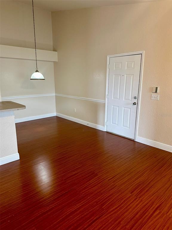 A dining area features wood-look flooring, a pendant light, and a white entry door — 3373 S KIRKMAN ROAD UNIT 939, ORLANDO, FL