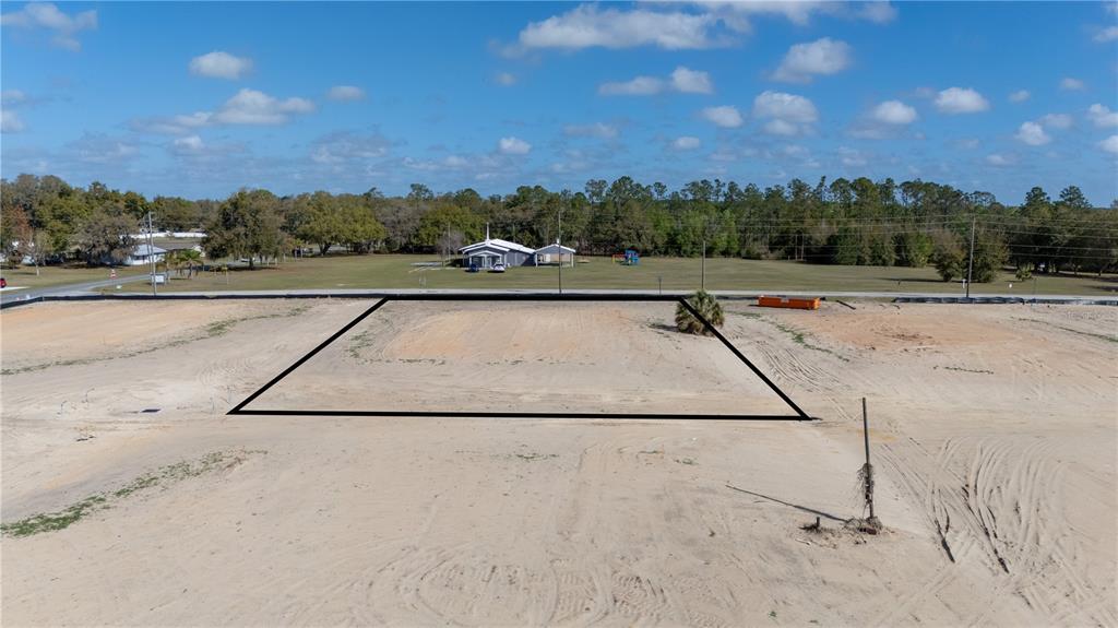 An aerial view shows a cleared, rectangular residential lot outlined in black against a sandy landscape — 32784 DUNNE ROAD, SAN ANTONIO, FL