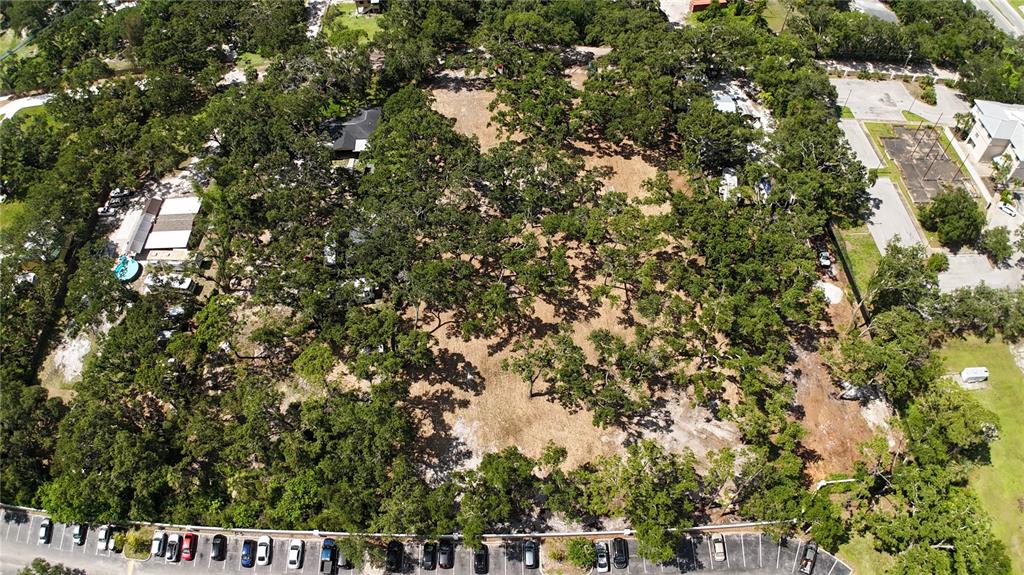 An aerial view shows a wooded lot bordered by a parking lot and residential buildings — 0 51ST STREET, SARASOTA, FL