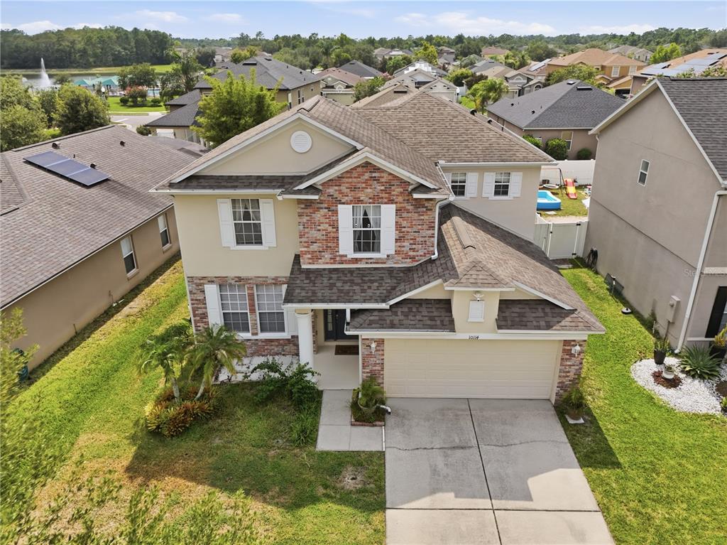 An aerial view of a two-story suburban house with a brick facade and attached garage — 10114 OAK CREST ROAD, ORLANDO, FL