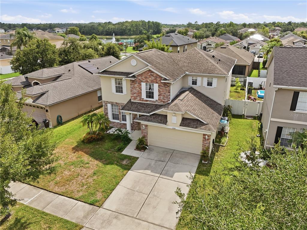 An aerial view of a two-story suburban house with a brick facade and attached garage — 10114 OAK CREST ROAD, ORLANDO, FL
