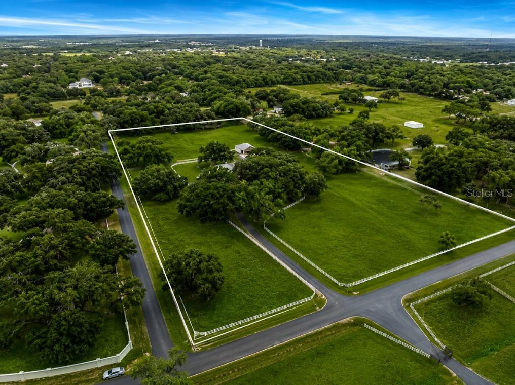 An aerial view shows a fenced rural property with a house, barn, and surrounding pasture — 1160 WAGON WHEEL DRIVE, SARASOTA, FL