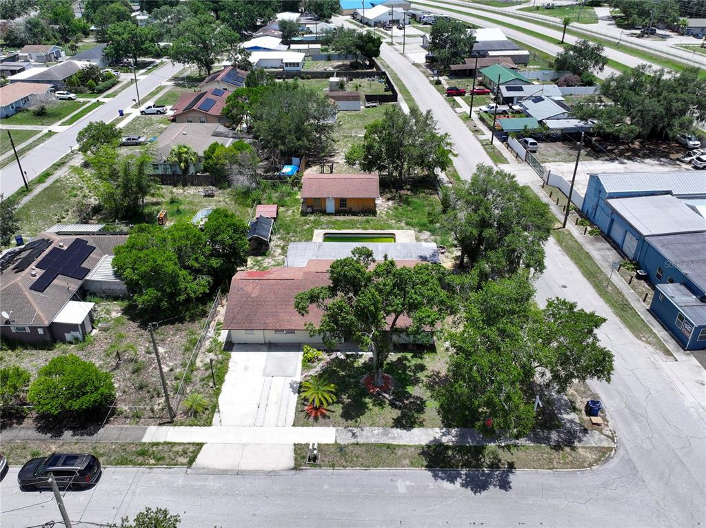 An aerial view shows a residential house with a pool, detached shed, and surrounding neighborhood — 505 FIELDER BOULEVARD, SEBRING, FL