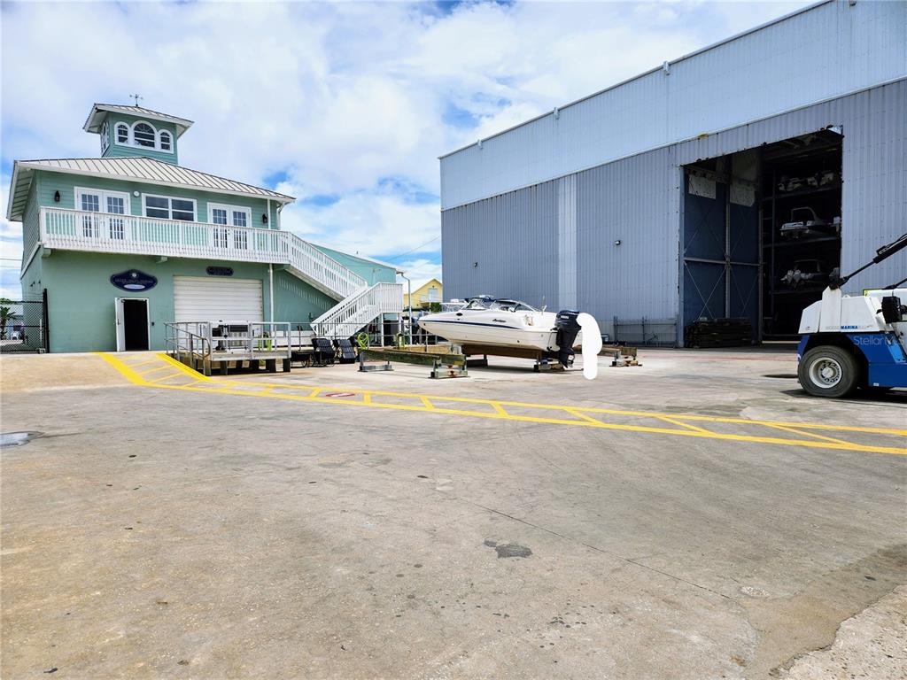 A light green two-story building stands next to a large metal boat storage warehouse — 100 CIRCUIT ROAD UNIT N12, NOKOMIS, FL