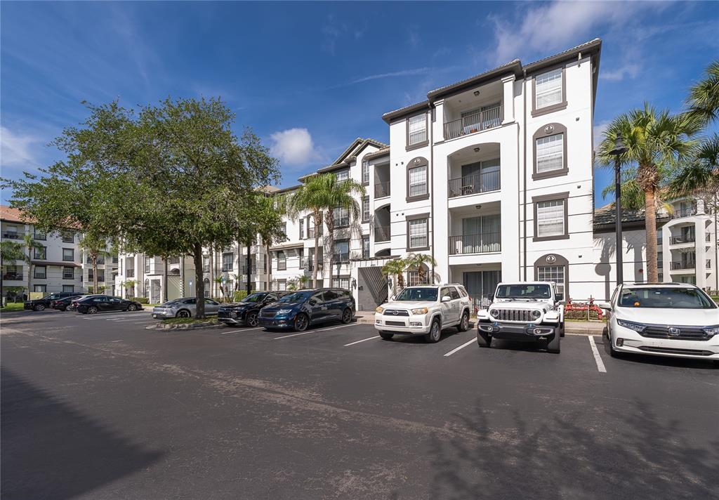 A multi-story apartment building with a parking lot in the foreground — 4102 BREAKVIEW DRIVE UNIT 40203, ORLANDO, FL