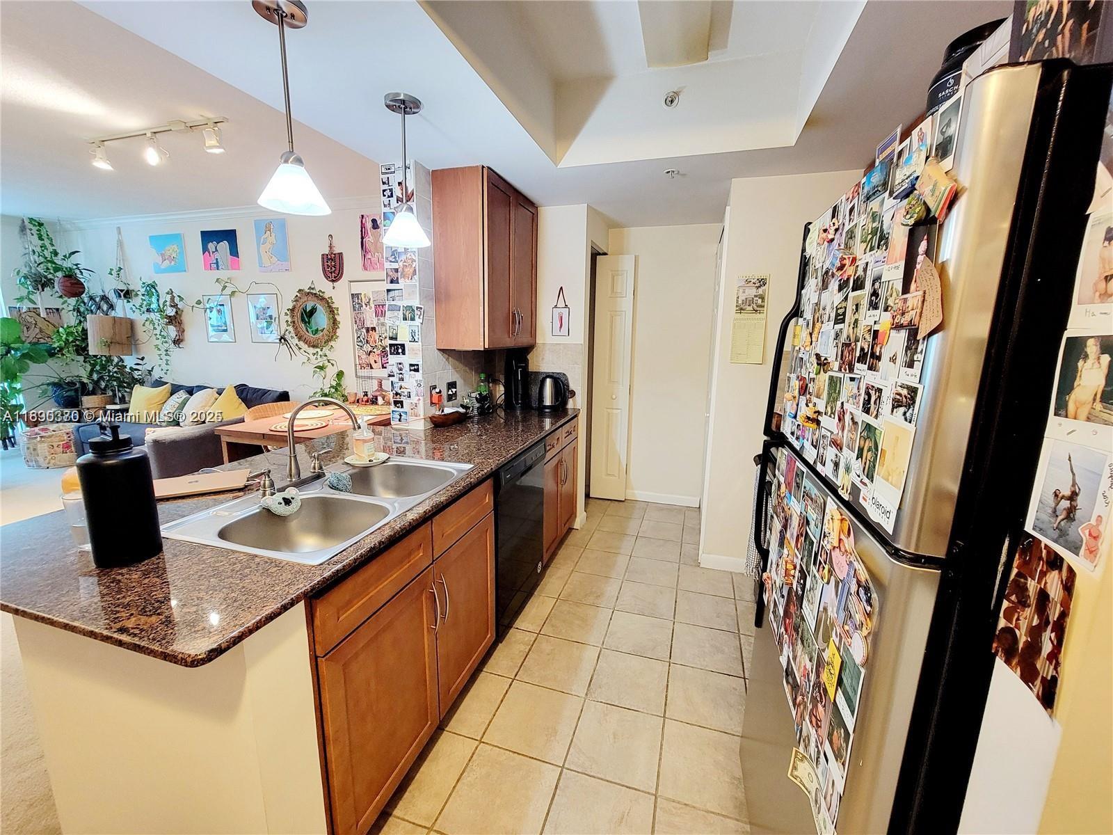 A kitchen with granite countertops, wood cabinets, and a refrigerator covered in photos — 2000 N Bayshore Dr # 226, Miami FL 33137, MIAMI, FL