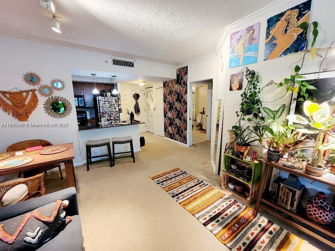 This living area features a kitchen, dining space, patterned wallpaper, and several potted plants — 2000 N Bayshore Dr # 226, Miami FL 33137, MIAMI, FL