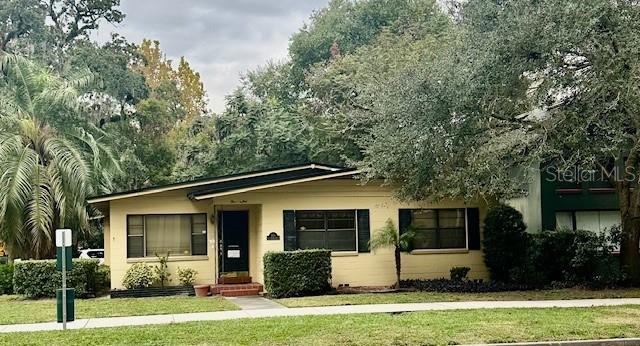 A single-story house with a yellow exterior, a dark roof, and large windows — 501 E CHURCH STREET, ORLANDO, FL