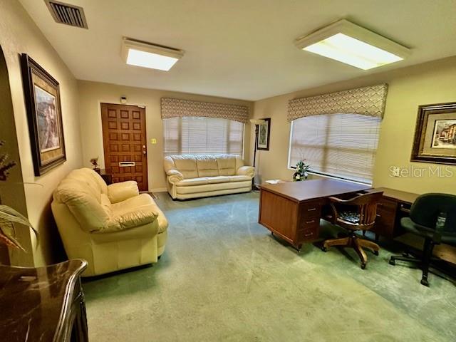 A room with a light-colored sofa, a wooden desk, and green carpeting — 501 E CHURCH STREET, ORLANDO, FL