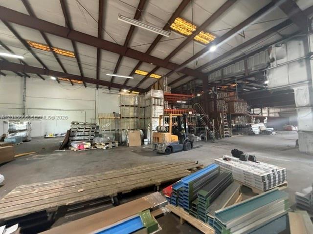 A large industrial warehouse interior features high ceilings, concrete floors, and stacked inventory materials — 7500 NW 74th Ave, Medley FL 33166, MEDLEY, FL