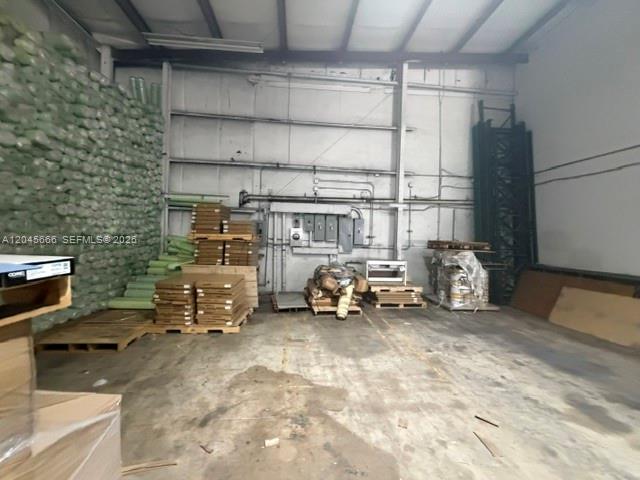 An industrial warehouse interior features concrete floors, exposed metal walls, and stacked inventory on pallets — 7500 NW 74th Ave, Medley FL 33166, MEDLEY, FL