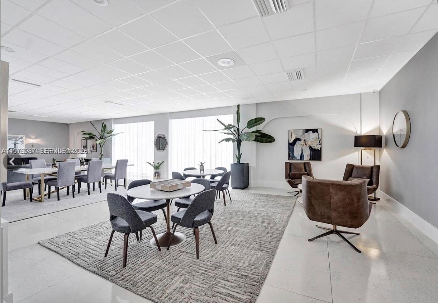 A modern, open-plan lounge area features multiple dining tables, seating groups, and large windows — 3140 S Ocean Dr # 1812, Hallandale Beach FL 33009, HALLANDALE BEACH, FL