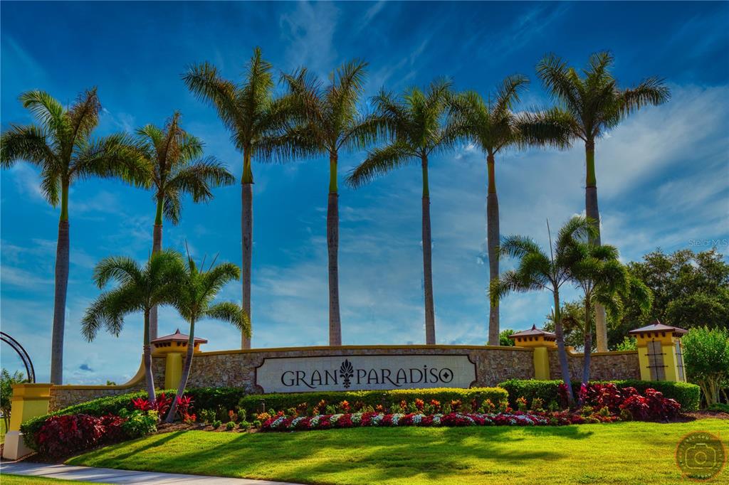 A stone entrance sign for Gran Paradiso stands in front of tall palm trees — 12355 GHIBERTI CIRCLE UNIT 101, VENICE, FL
