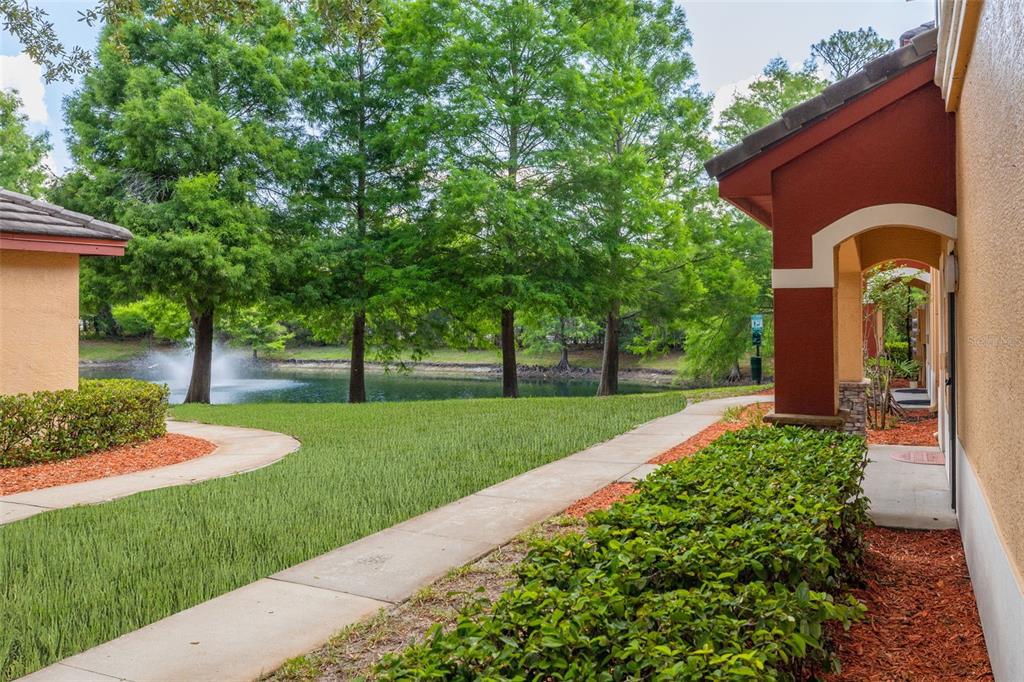 A two-story yellow stucco apartment building with red trim and white window shutters — 2262 CHIANTI PLACE UNIT 5-0511, PALM HARBOR, FL