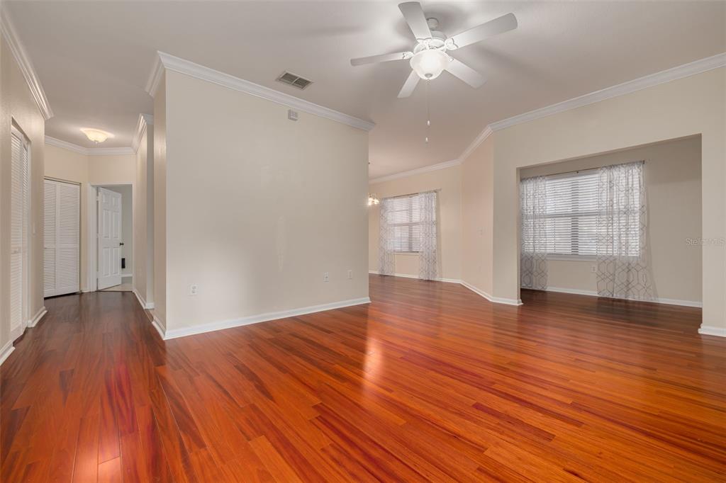 A living room with hardwood floors, a white sofa, a coffee table, and a television — 2262 CHIANTI PLACE UNIT 5-0511, PALM HARBOR, FL