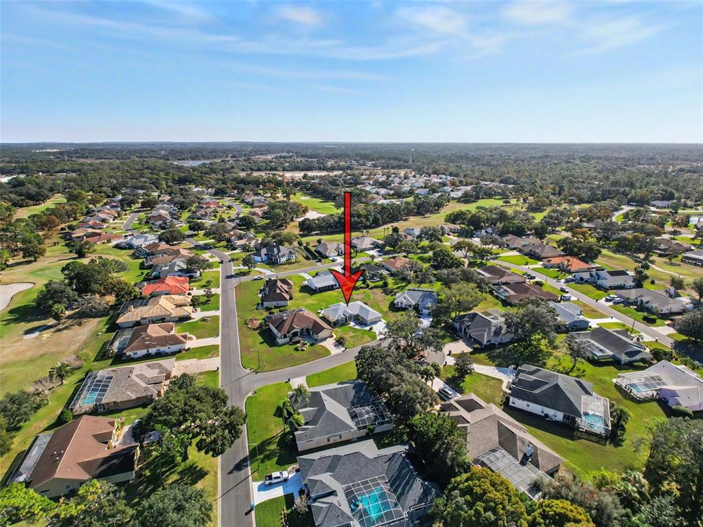 An aerial view shows a residential neighborhood with a red arrow pointing to a house — 9428 APPLE DUMPLING COURT, WEEKI WACHEE, FL