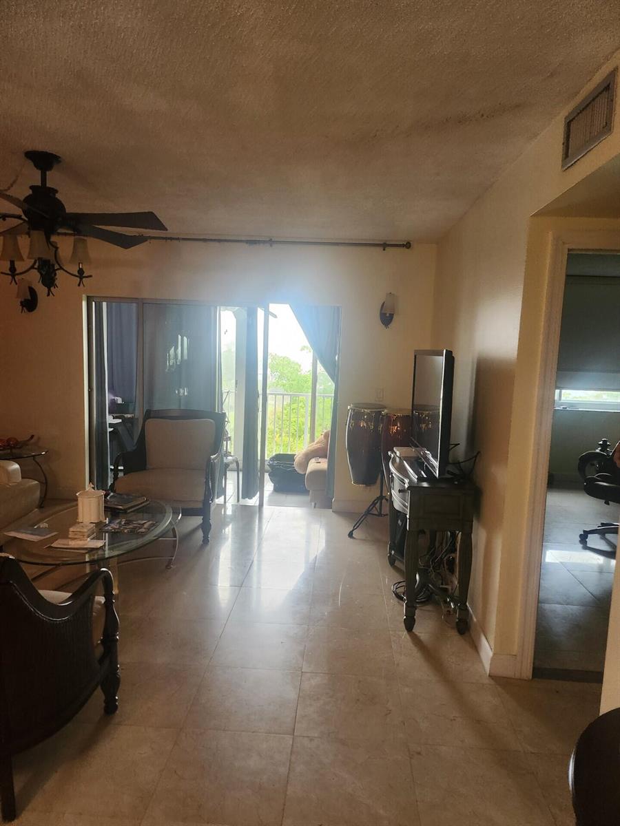 A living room with tile floors, a ceiling fan, and a sliding door to a balcony — 4200 Hillcrest Drive # 707, Hollywood FL 33021, HOLLYWOOD, FL