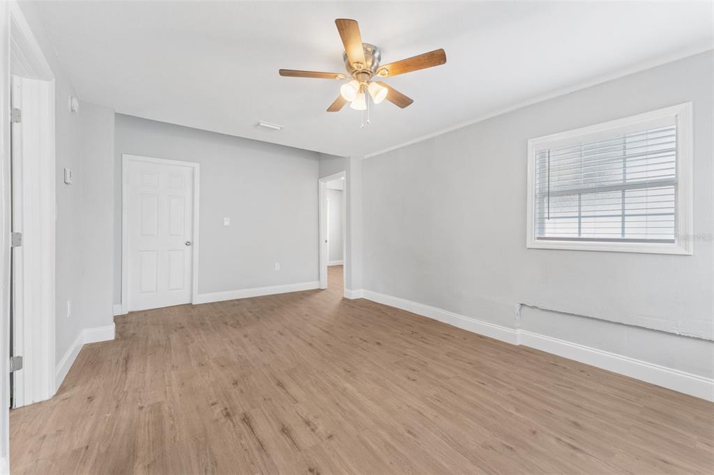 An empty room with light gray walls, wood-look flooring, a ceiling fan, and a window — 1927 13TH STREET S, ST PETERSBURG, FL