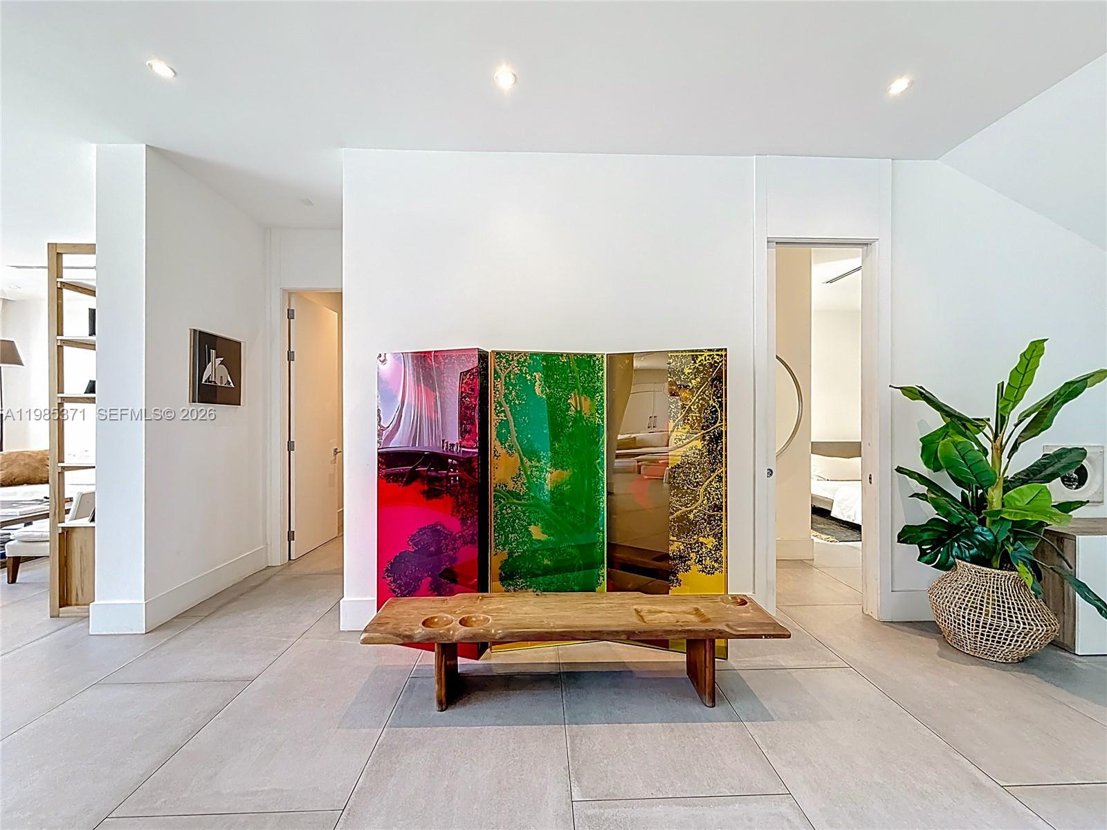 A hallway features a wooden bench, a colorful three-panel screen, and a potted plant — 561 Warren Ln, Key Biscayne FL 33149, KEY BISCAYNE, FL