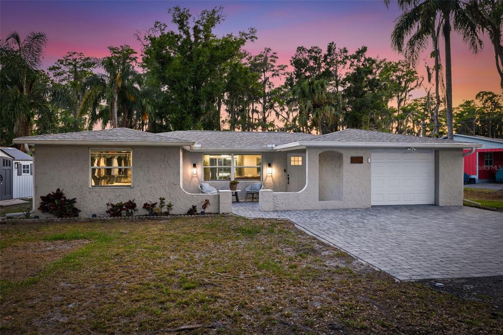 A single-story house with a stucco exterior, a paved driveway, and a small front patio — 14702 BLUESTONE LANE, ODESSA, FL