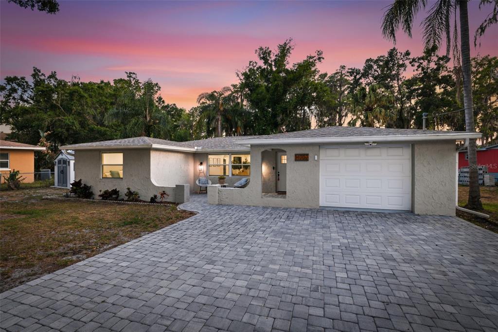 A single-story house with a paved driveway, a garage, and a small front patio area — 14702 BLUESTONE LANE, ODESSA, FL
