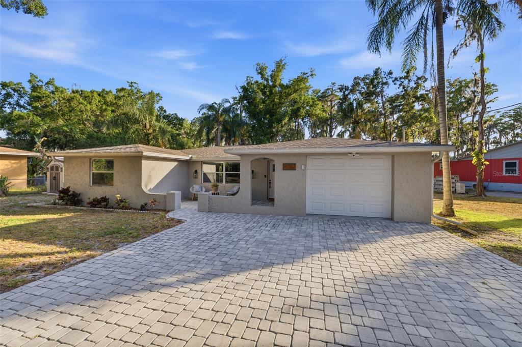 A single-story house with a paved driveway, a one-car garage, and a small front patio — 14702 BLUESTONE LANE, ODESSA, FL