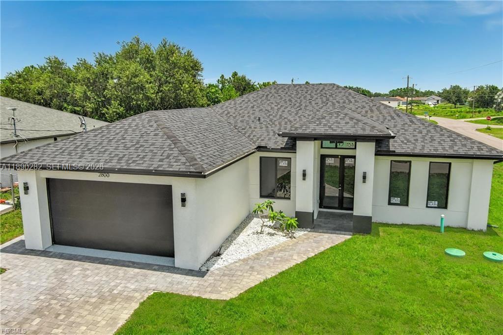 A modern single-story house with a two-car garage, white stucco walls, and a shingled roof — 2800 33rd ST SW, Lehigh Acres FL 33976, LEHIGH ACRES, FL
