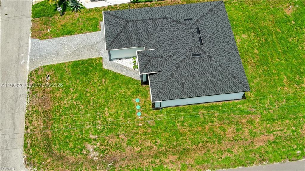 An aerial view shows a single-story house with a dark shingled roof and a driveway — 2800 33rd ST SW, Lehigh Acres FL 33976, LEHIGH ACRES, FL