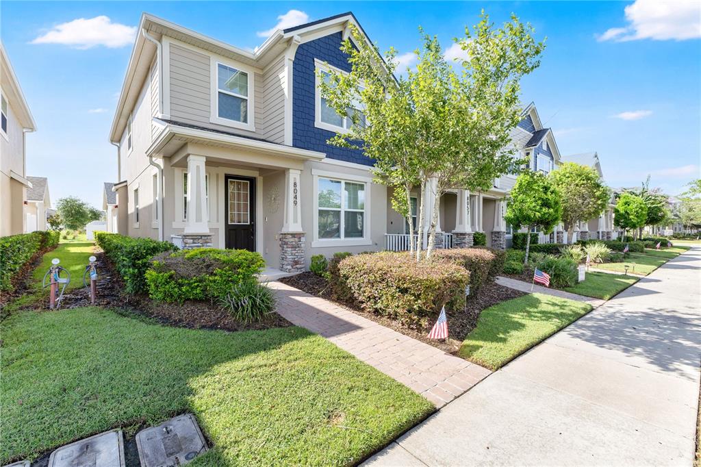 A two-story house with beige siding, blue shingles, and a brick walkway — 8049 CADMAN STREET, ORLANDO, FL