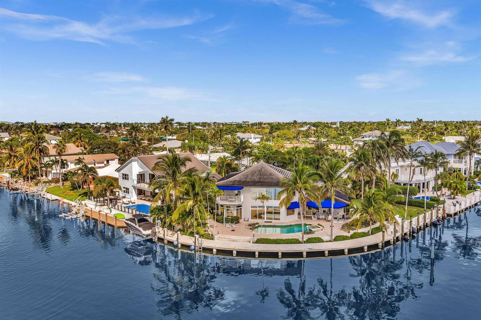 An aerial view of a waterfront house with a pool, boat dock, and palm trees — 2888 NE 33rd Street, Lighthouse Point FL 33064, LIGHTHOUSE POINT, FL