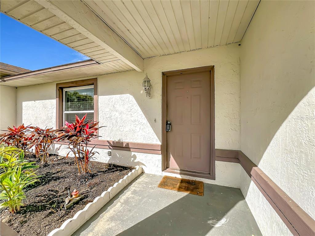 A single-story house with a tan roof, white stucco exterior, and a two-car garage — 6449 ROYAL TERN STREET, ORLANDO, FL